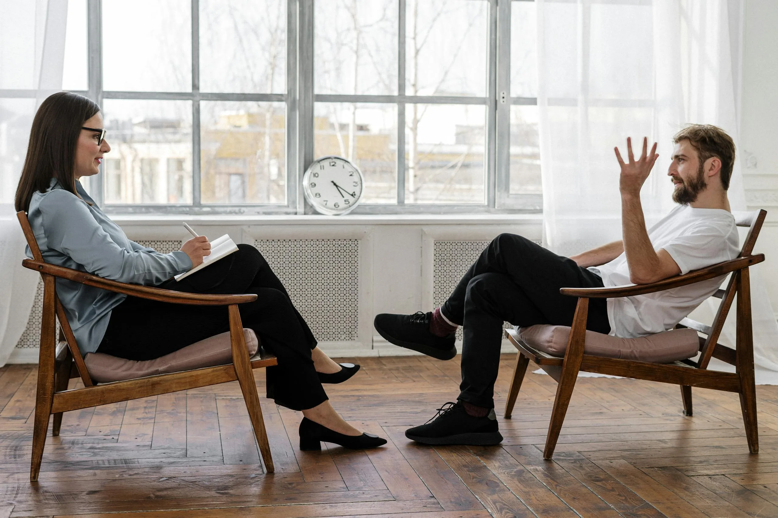 Photo by cottonbro studio Person in Black Pants and Black Shoes Sitting on Brown Wooden Chair
